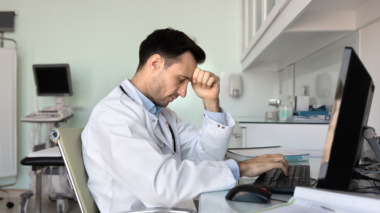 professional in front of a computer, worn down, tired