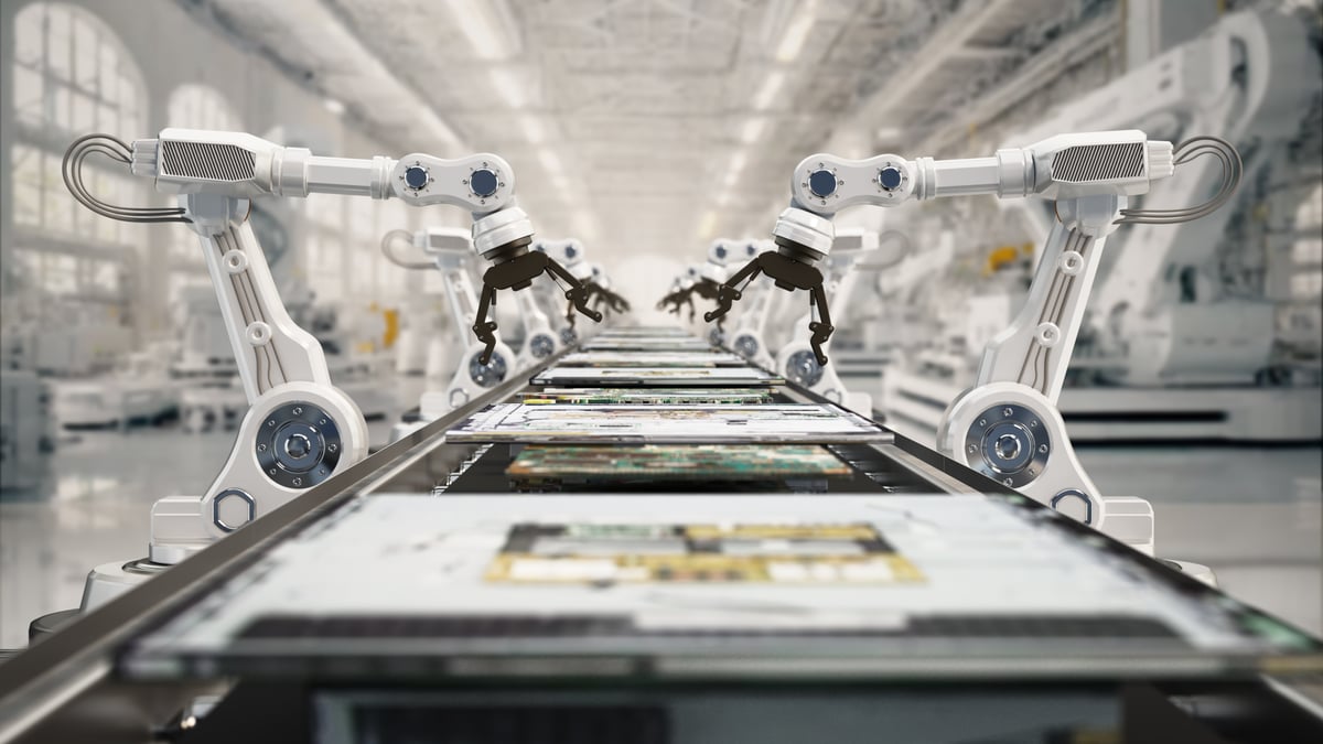 Robot arms work on an assembly line.