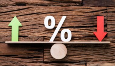 A green up arrow and a red down arrow are arranged on opposite ends of a fulcrum, and a percent sign sits between the two.