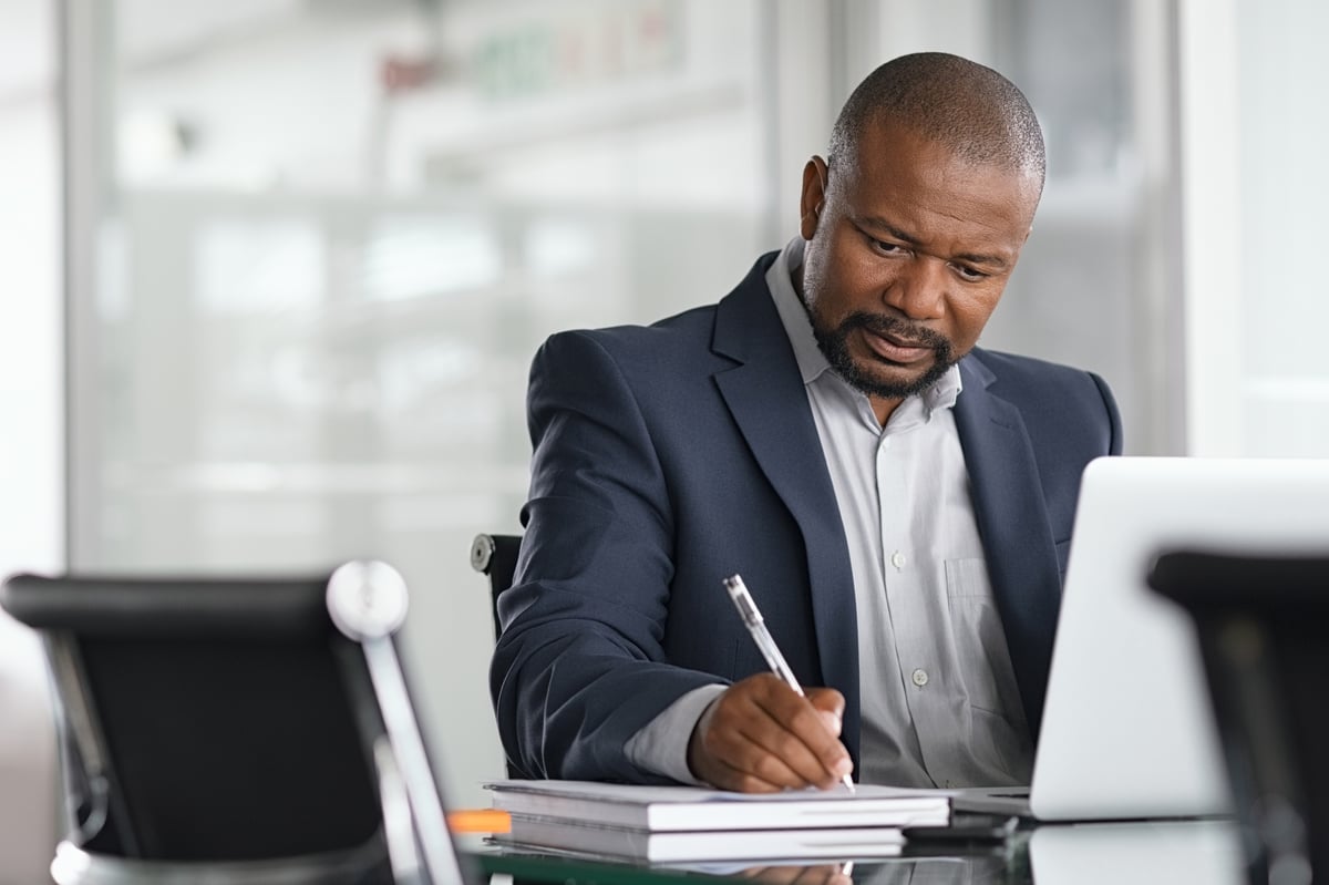 A person at a laptop, writing.