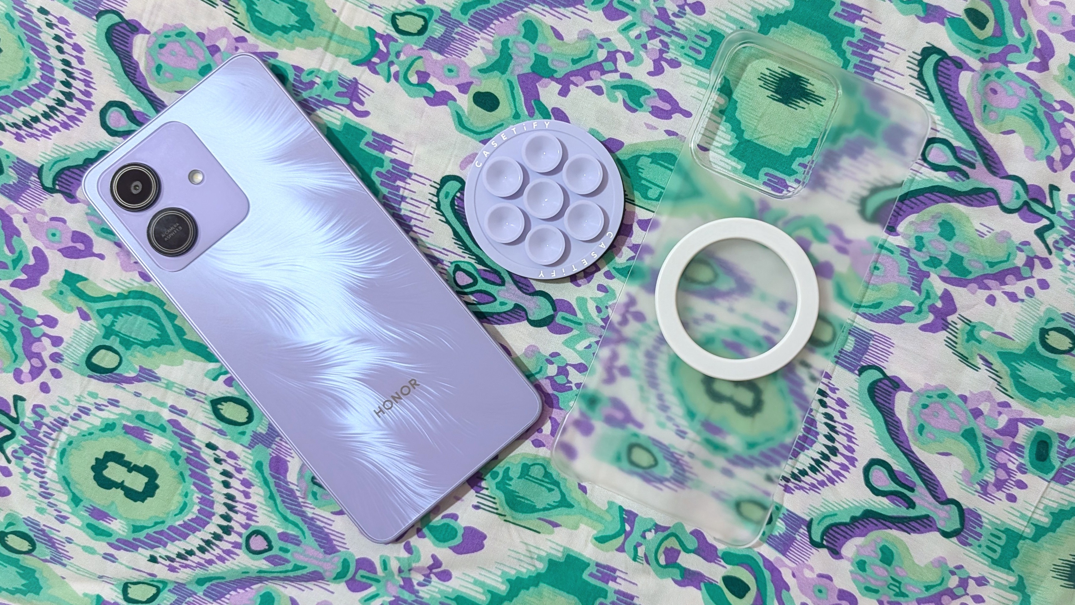 Honor Play 10 with a clear case, a magnetic ring sticker, and MagSafe accessories.