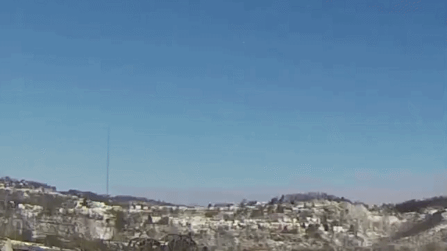 Looped video footage of a fireball meteor exploding in the daytime sky
