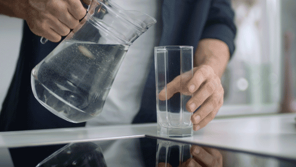 Man pouring water into glass