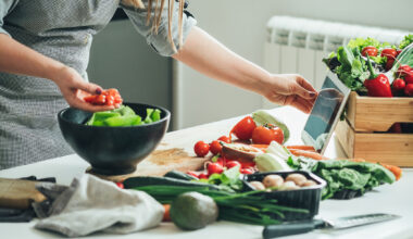 Woman utilizing tablet in the kitchen while cooking (Getty Images/Tijana Simic)