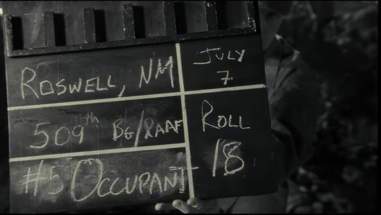 A black-and-white filmmaking clapboard