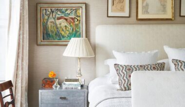 A bed with a beige fabric headboard and metallic bedside drawers