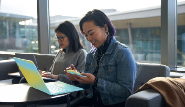 Two security workers sit at laptops.