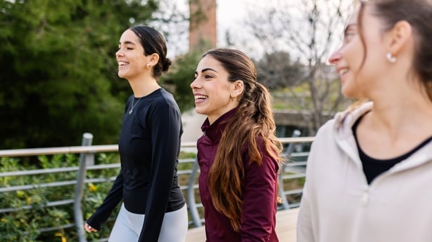 Three athletic young women enjoying a walk together outdoors, promoting a healthy and active lifestyle