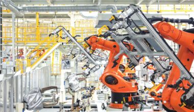 Industrial robot arms operate at the vehicle body workshop of Volkswagen