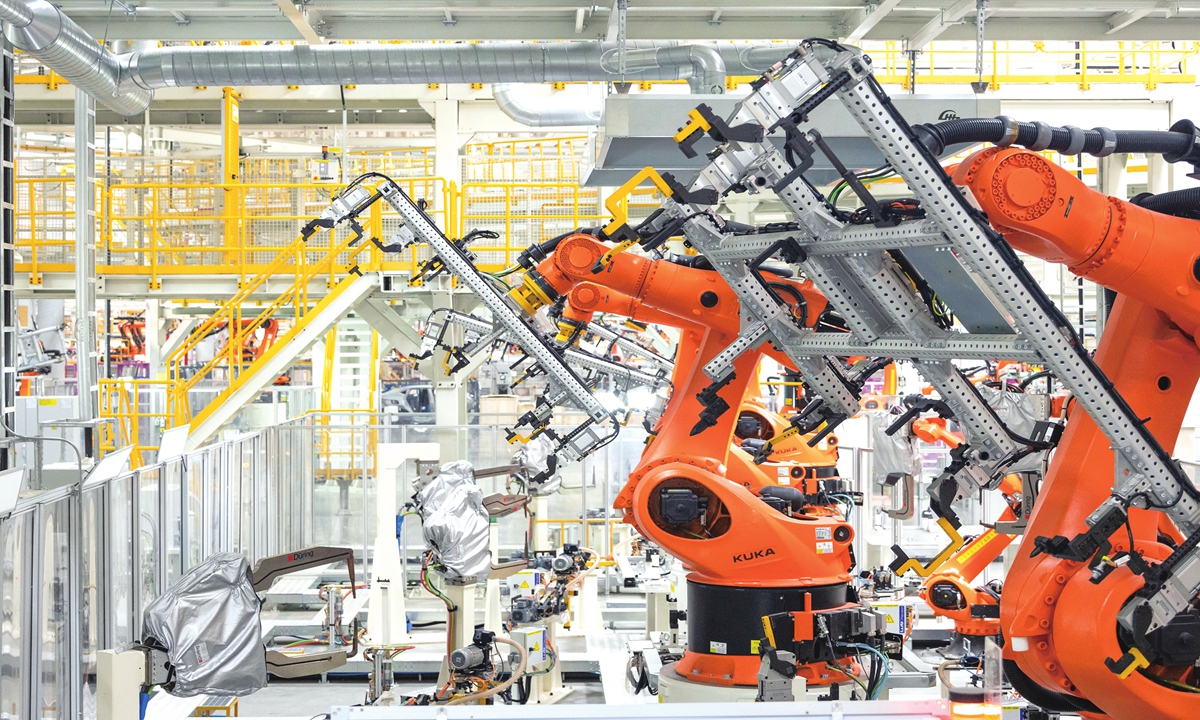 Industrial robot arms operate at the vehicle body workshop of Volkswagen