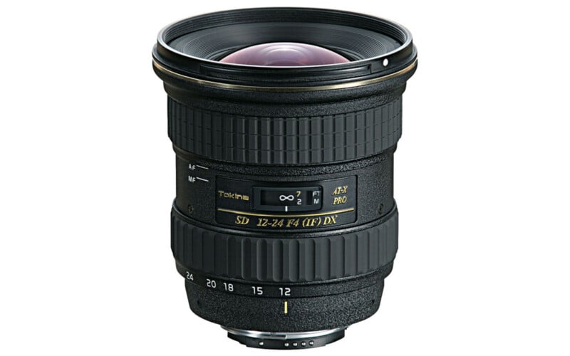 A Tokina AT-X PRO SD 12-24mm F4 (IF) DX camera lens is shown standing upright on a white background, displaying its focus and zoom rings, focal length markings, and gold branding text.