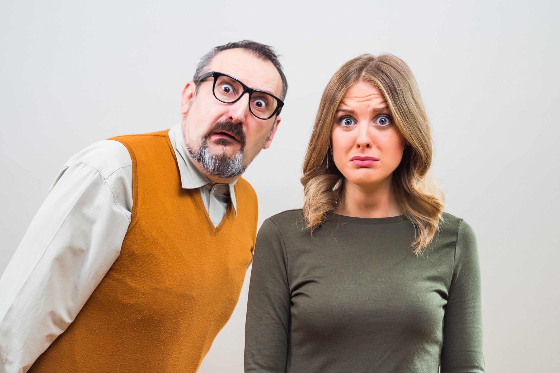 A couple is staring at the camera, looking amazed and bewildered.