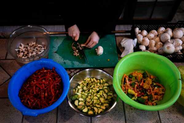 A monk prepares meals at the Monastery of St. Augustine and Seraphim of Sarov ahead of Easter as part of annual Lenten dietary restrictions in the village of Trikorfo, about 236 kilometers (147 miles) northwest of Athens, Friday, March 20, 2026. (AP Photo/Thanassis Stavrakis)