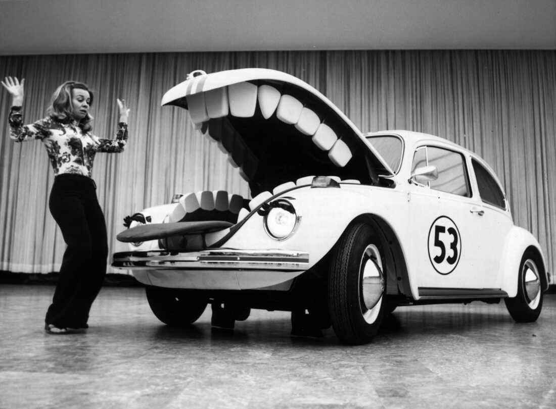 Herbie, the anthropomorphic Volkswagen Beetle featured in the 1969 Disney film "The Love Bug" and its sequels, terrorizes a young woman at a car show in Berlin in June 1972. (Photo by Keystone/Hulton Archive/Getty Images)
