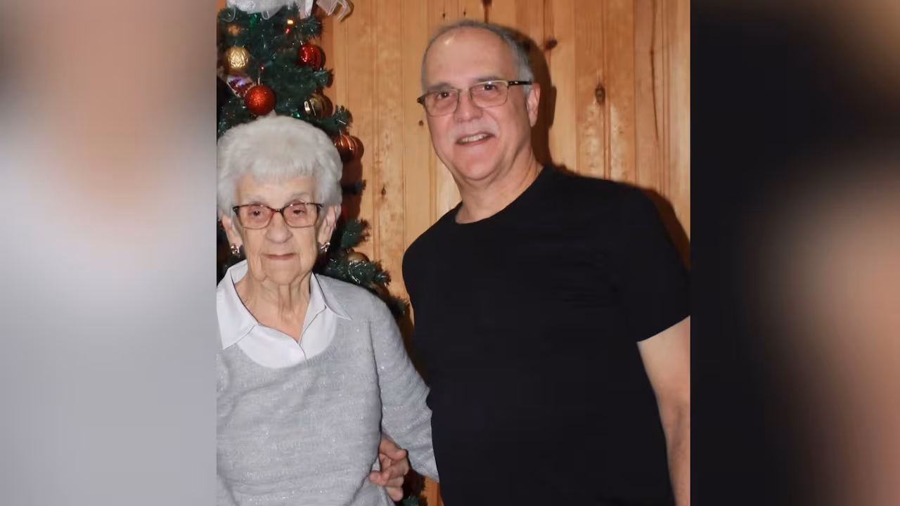 A man standing with an elderly woman.