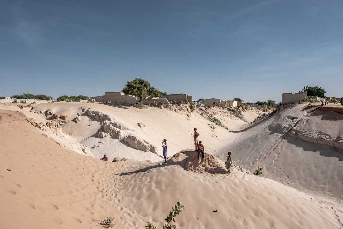 Boys stand on the edge of the town of Mao in Kanem Province, Chad, where desertifcation and land degradation are an increasing threat to the ability of local people to grow food. Temperatures in the Sahel are rising 1.5 times faster than the global average and the population is growing faster than anywhere else in the world. 135 million people in the region rely on degraded land.