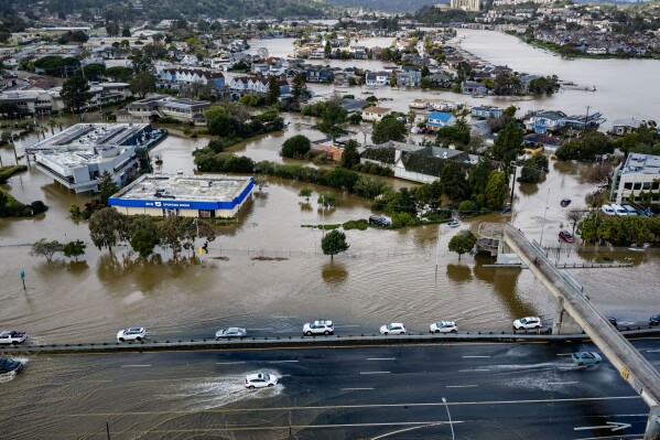 Cars drive on highway 101 flooded by a king tide, the year's highest tides, Jan. 3, 2026, near Corte Madera in Marin County, Calif. (AP Photo/Ethan Swope, File)