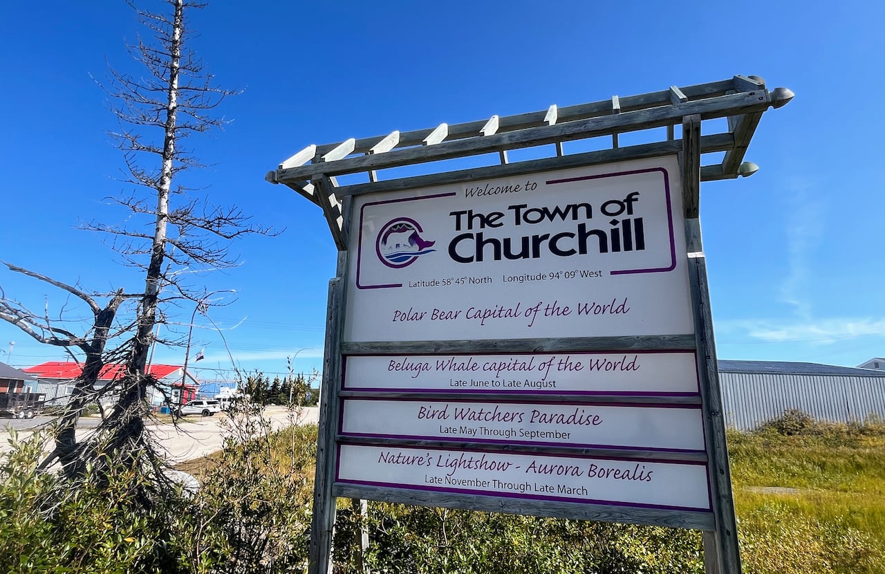 A sign reads "Churchill, Manitoba," and has slogans including "polar bear capital of the world" and "beluga whale capital of the world."