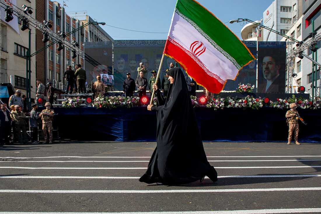 woman is seen carrying an Iranian flag during a pro-government National Army Day demonstration on April 17, 2026 in Tehran, Iran.