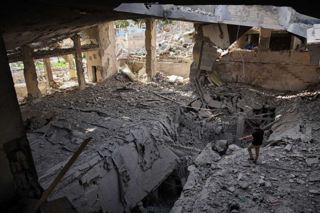A man walks among debris in a mosque destroyed in an Israeli airstrike in Jibchit, southern Lebanon, Friday, following the start of a temporary ceasefire between Israel and Hezbollah.