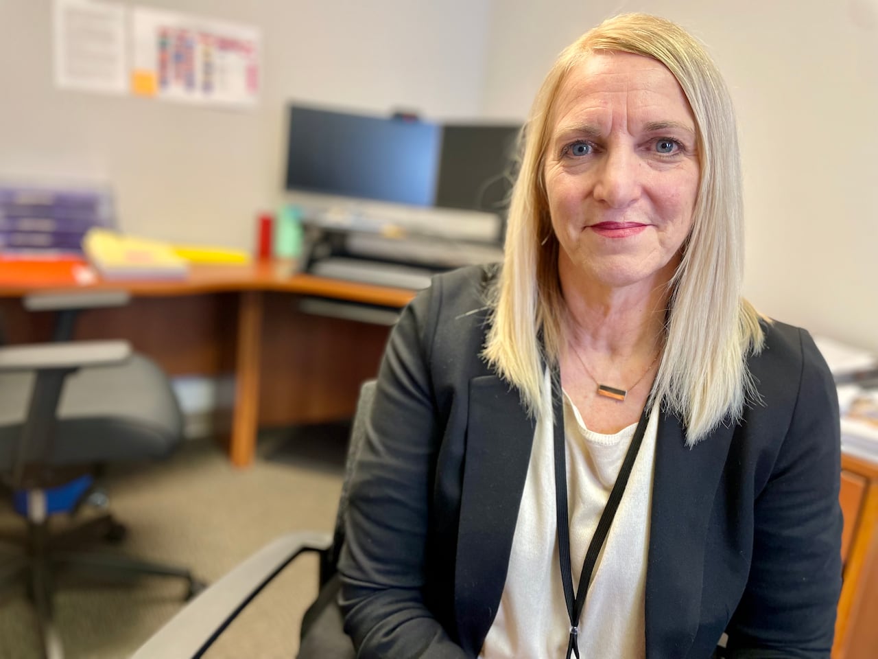Woman with blonde hair and dark kacket.