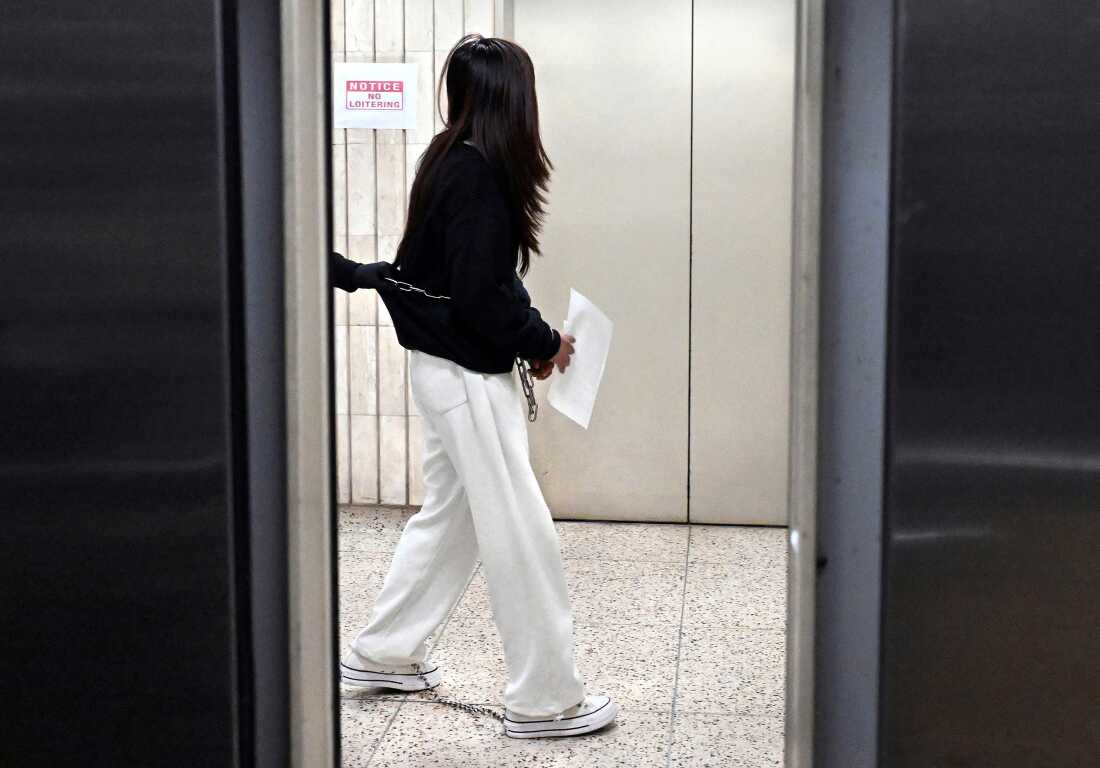 A woman is led in shackles through the Jacob Javits building’s 10th floor in New York City. 