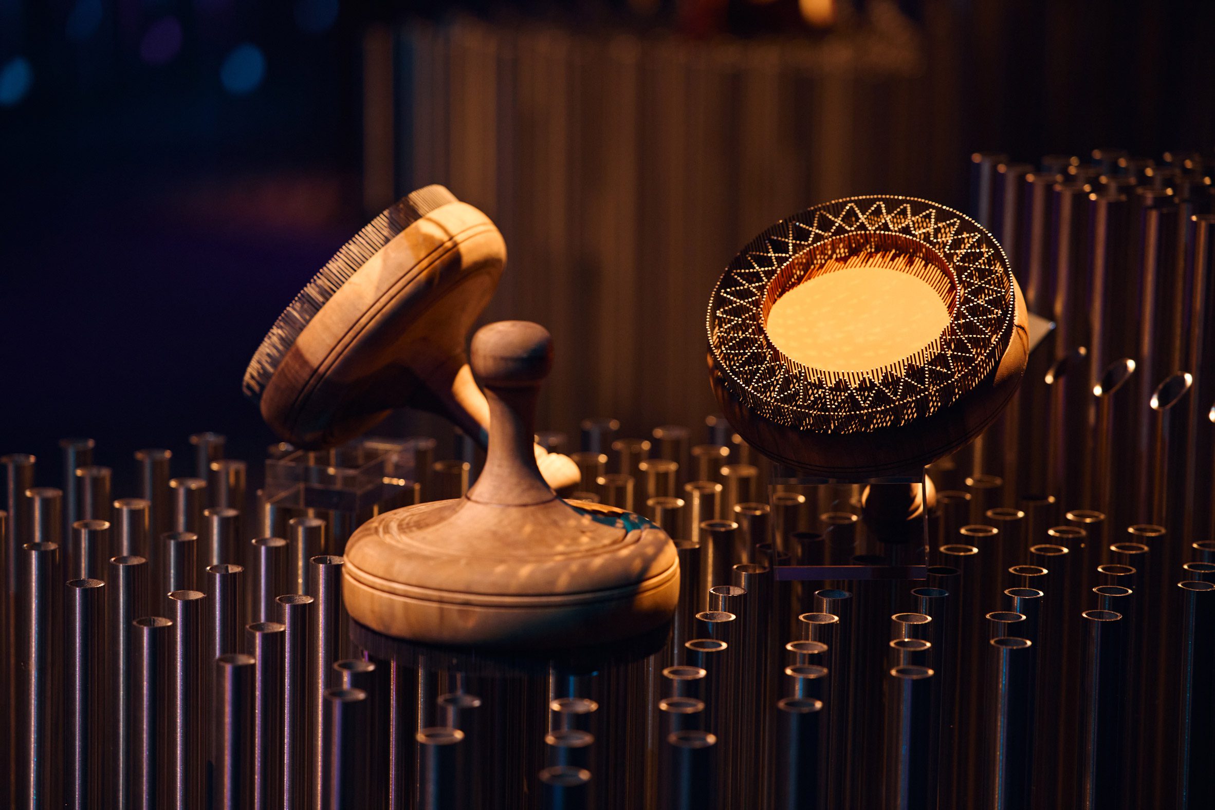 Wooden bread stamps with carved circular patterns displayed on metal rods