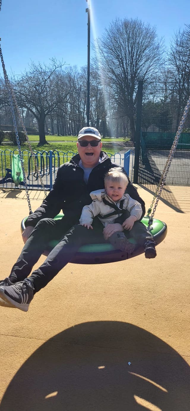 Darren with his son Daniel on a swing