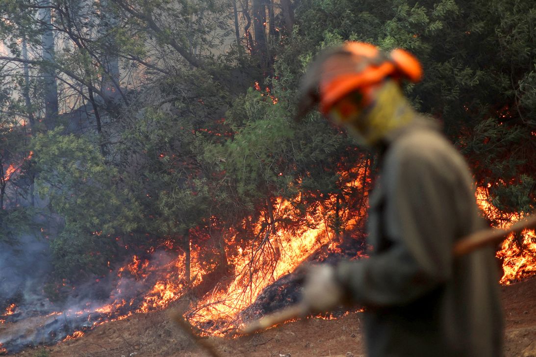 A firefighter by a fire in the Biobío region of Chile on January 21, 2026.