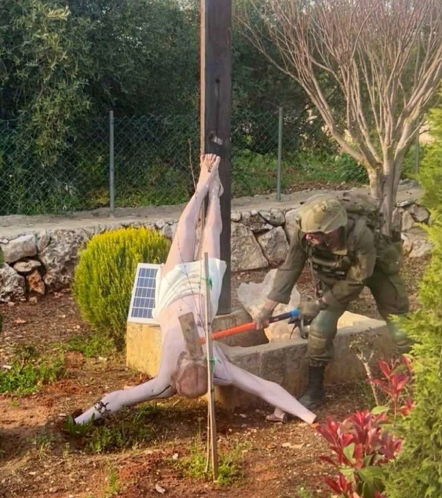 An Israeli soldier damages the head of a statue of Jesus, in Debel, Lebanon, in this still image obtained from social media released on April 19, 2026.