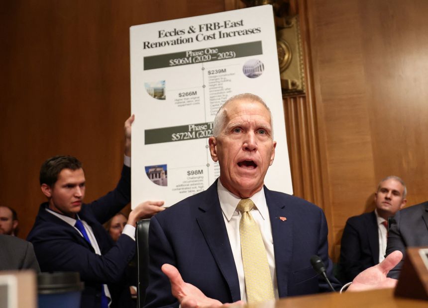 US Senator Thom Tillis (R-NC) speaks, while a placard titled 