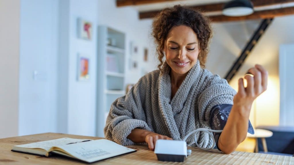 A woman checking her blood pressure in the morning to see if it's high