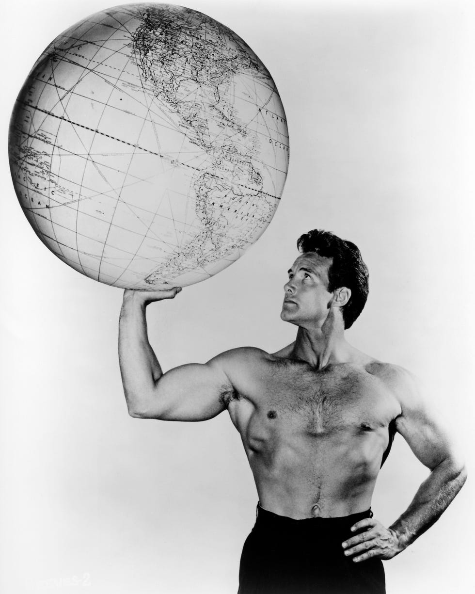 american bodybuilder and actor steve reeves (1926 2000) holding up a large globe, circa 1960. (photo by silver screen collection/getty images)