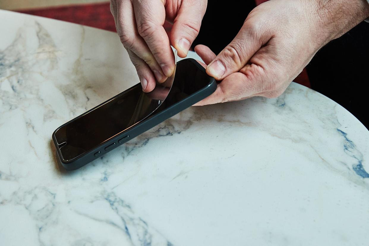 Applying a screen protector to a smartphone.