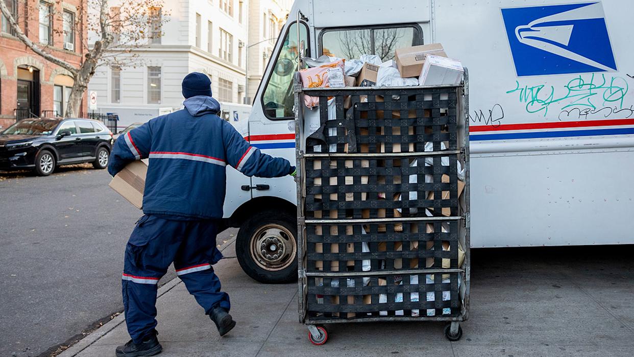 A United States Postal Service (USPS) worker delivering packages.