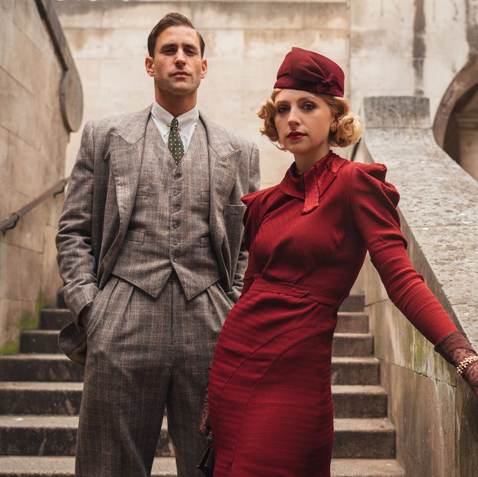 a couple in vintage attire posing on a staircase a couple in vintage attire posing on a staircase
