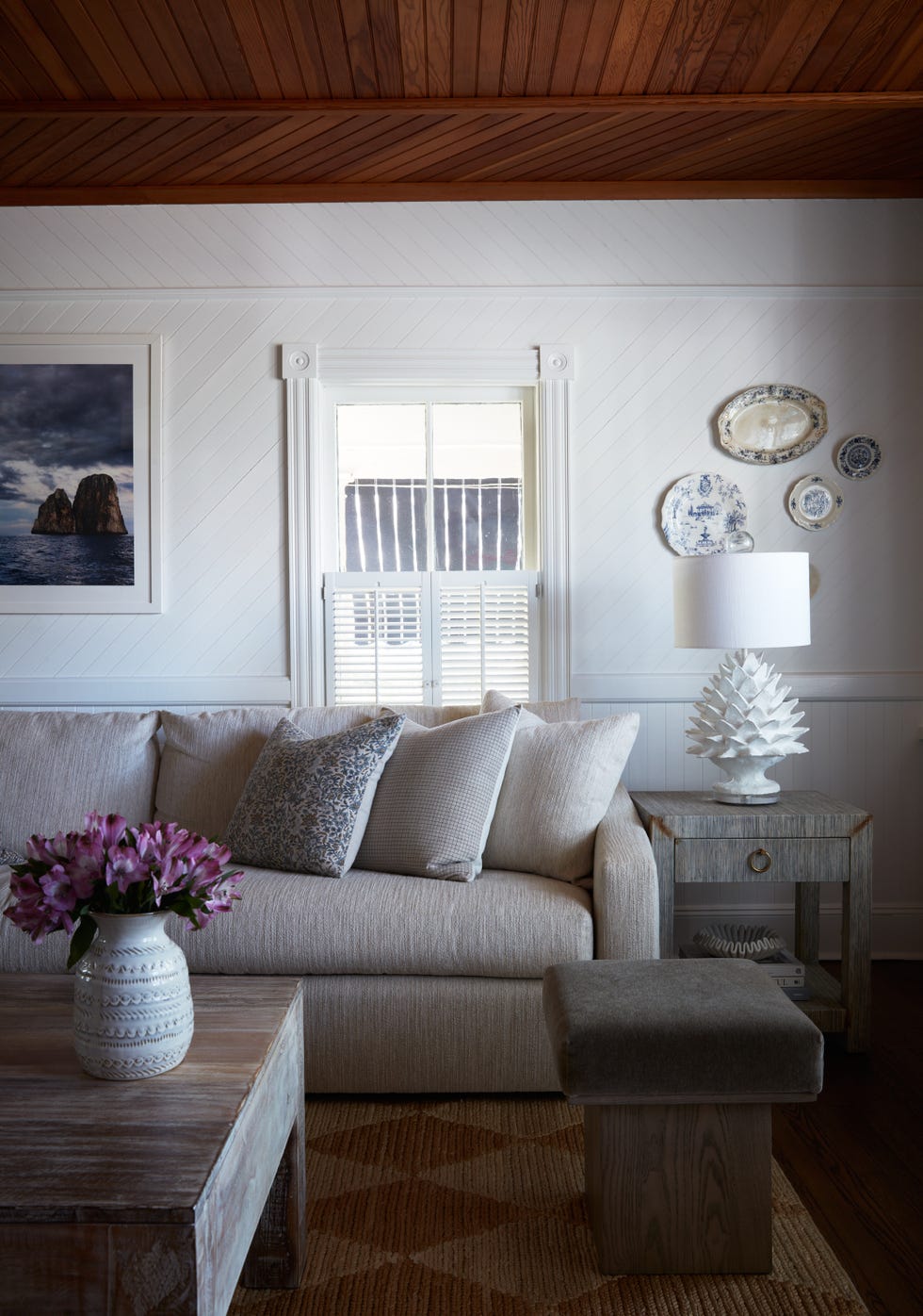 Cozy living room featuring a sofa, coffee table, decorative items, and window.
