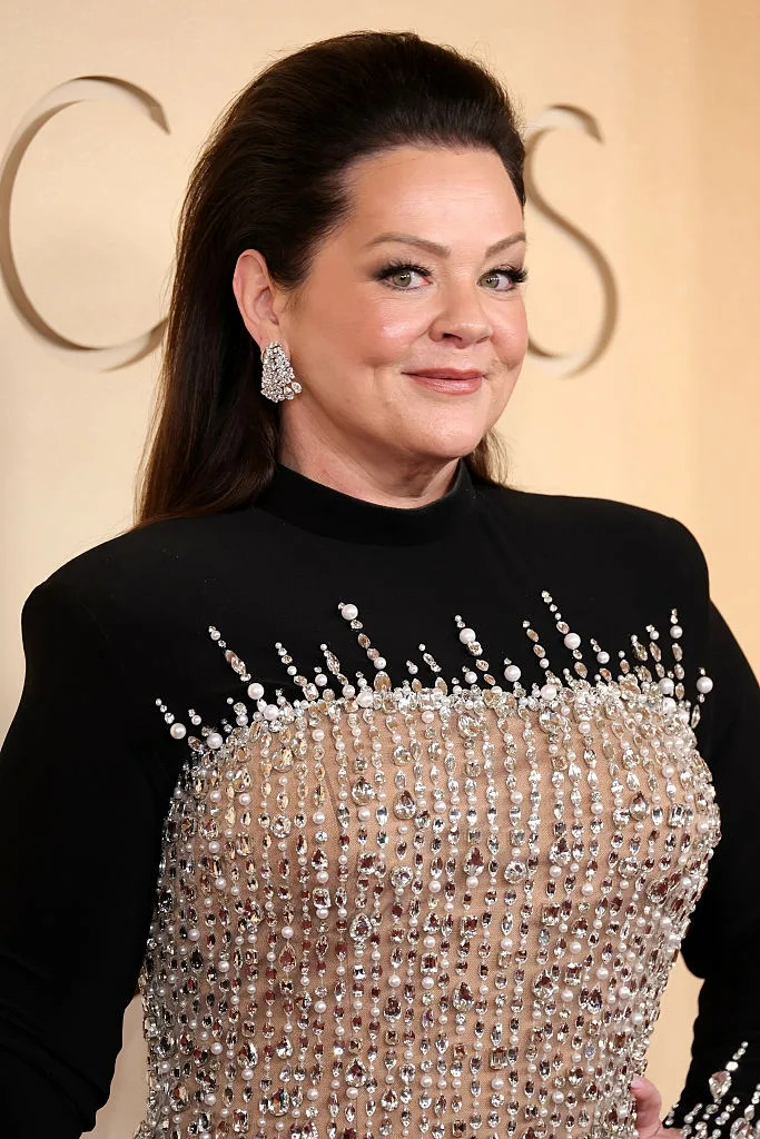 sparkling embellishments and shoulder-length hair, posing at a formal event