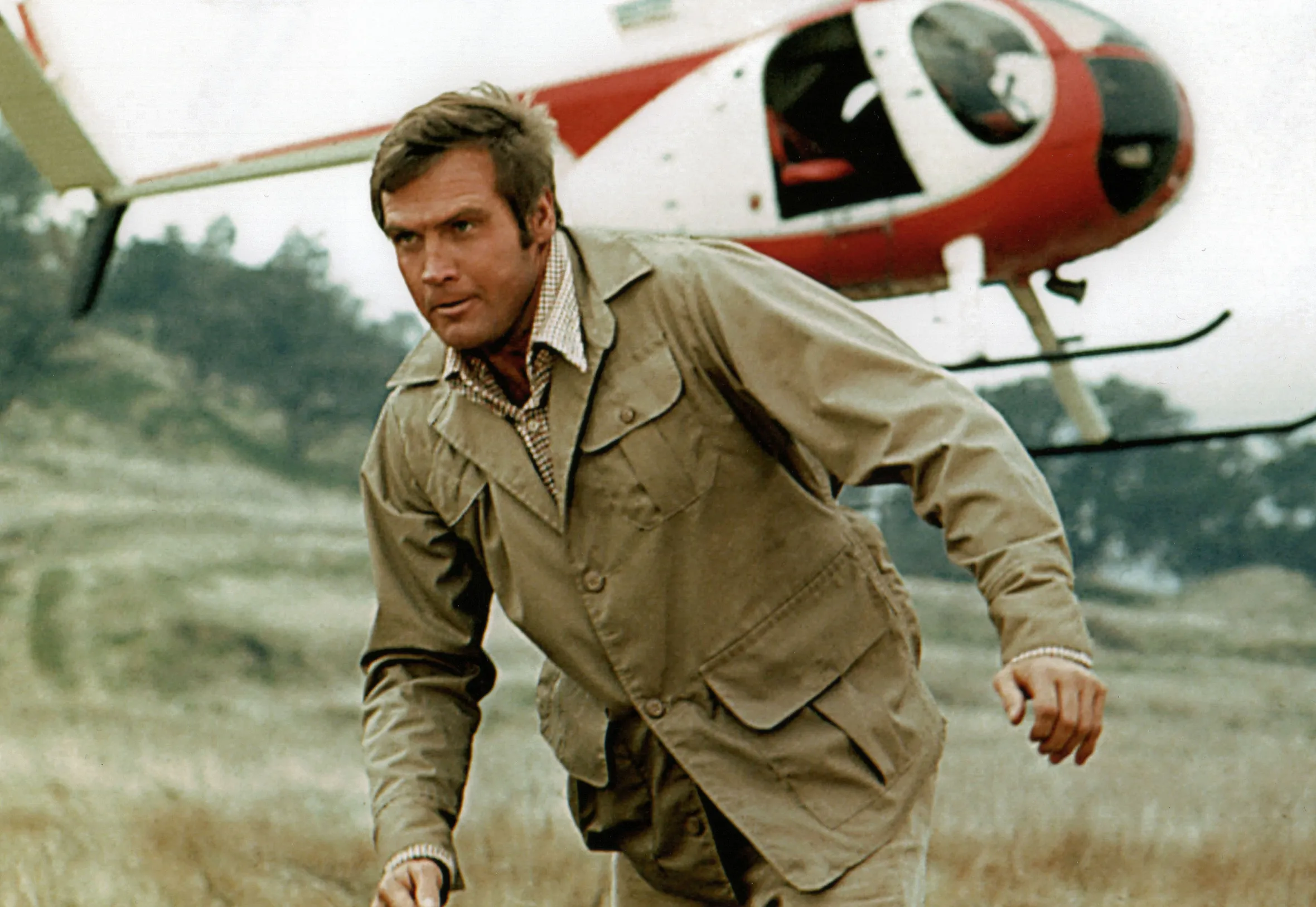Lee Majors as Steve Austin running in front of a helicopter in "The Six Million Dollar Man" (1974).