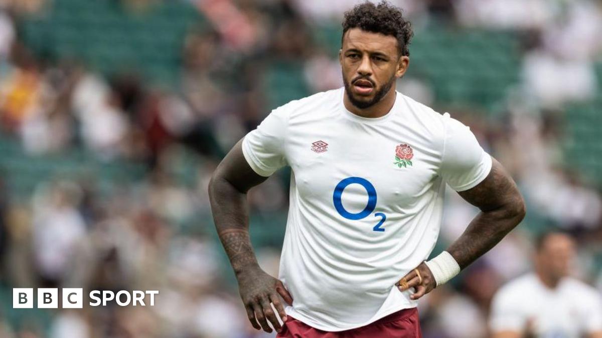Courtney Lawes standing on the pitch with an England shirt on and his hands on his hips