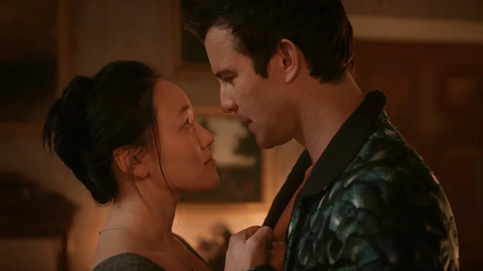  Sophie looking up at Benedict, they're holding each others' hands to their chests. . 