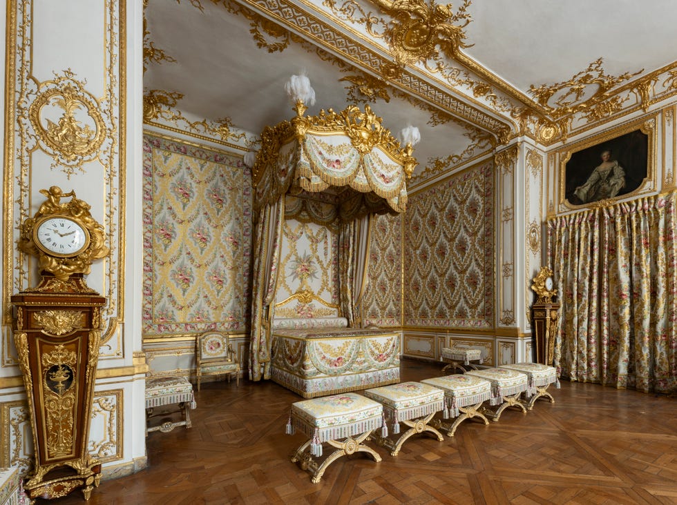 Ornate royal bedroom with a canopied bed.