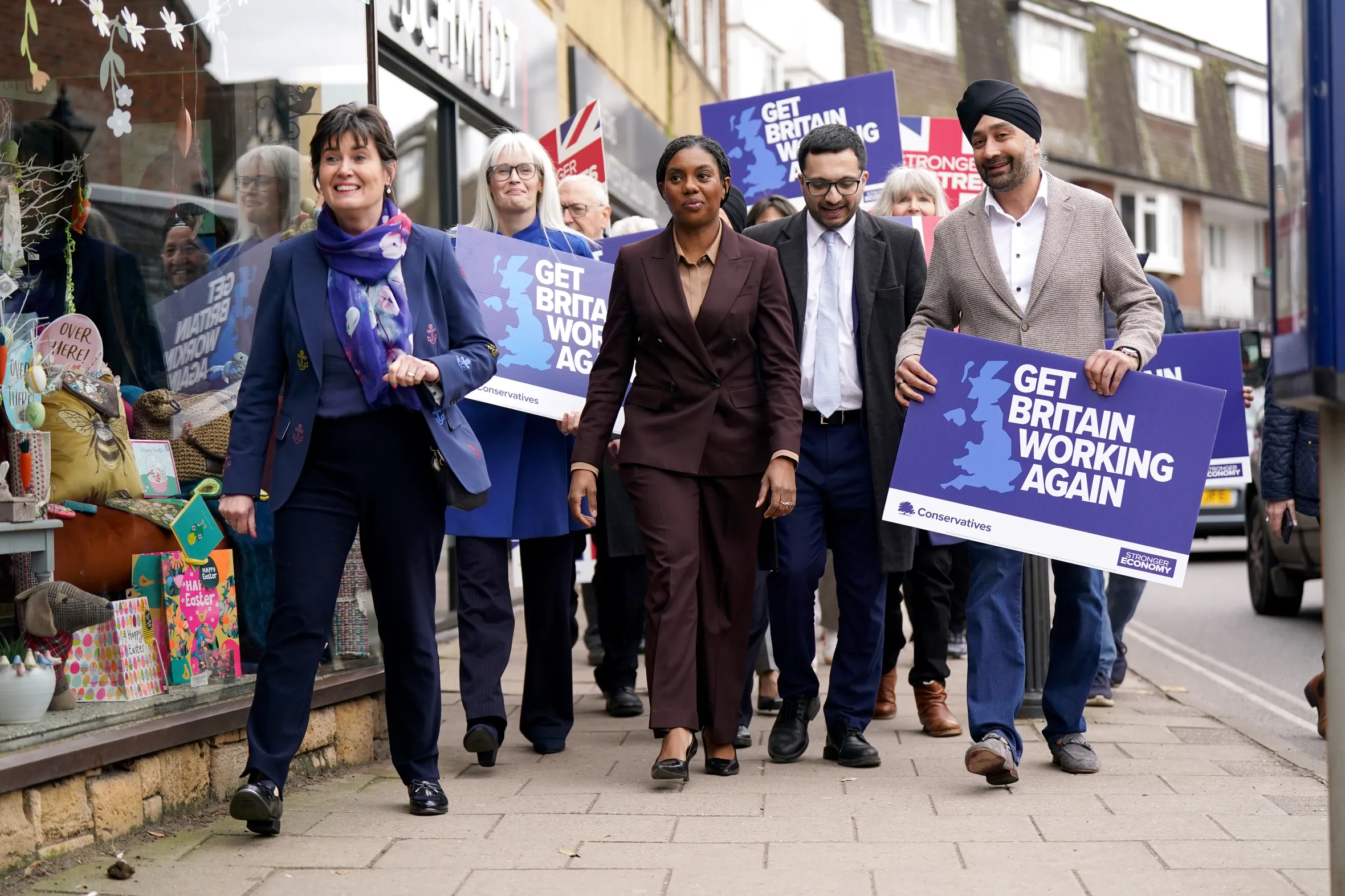 Conservative Party leader Kemi Badenoch on the campaign trail in Knowle, West Midlands, surrounded by supporters holding "Get Britain Working Again" signs.