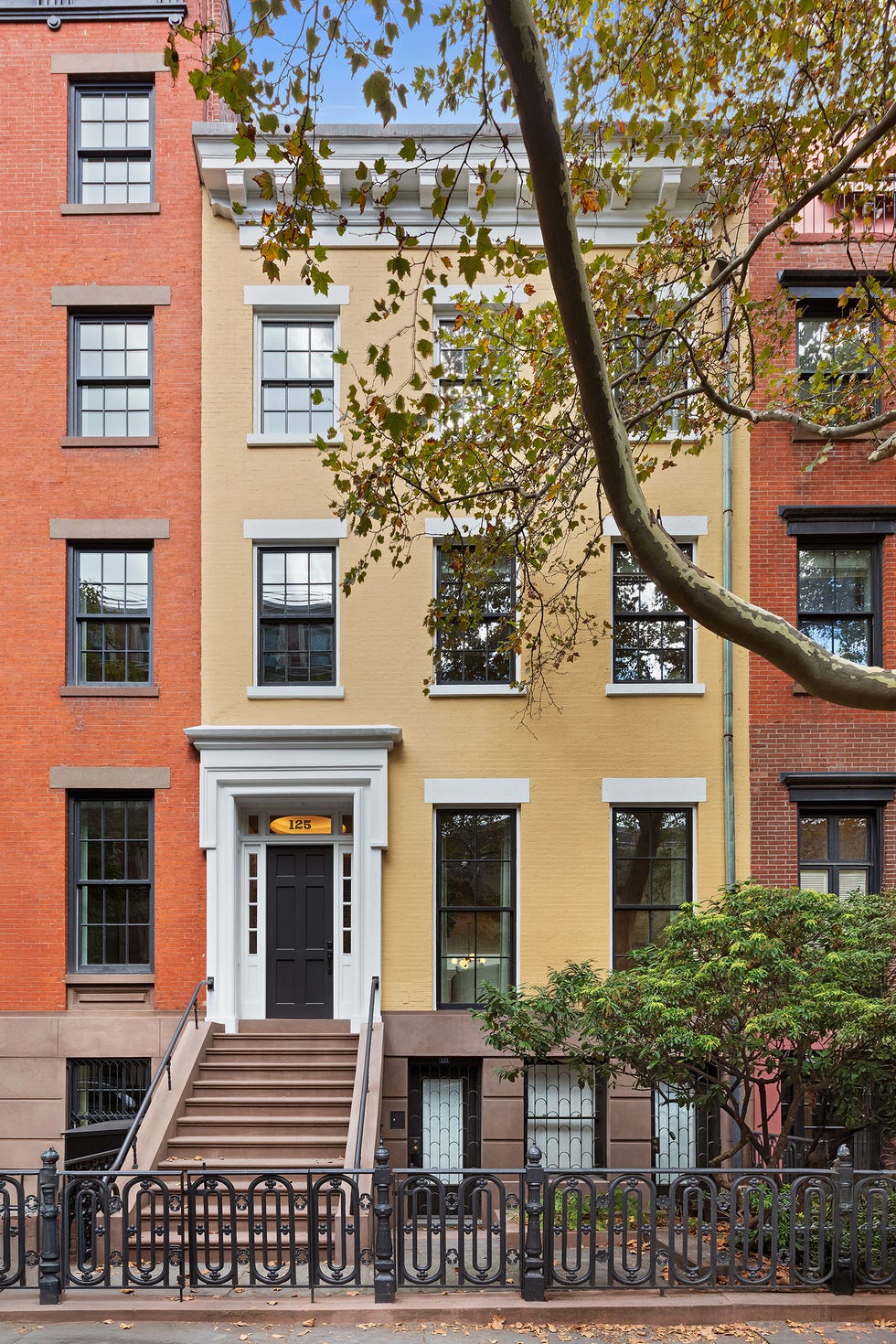 Front exterior of a multi-story building with a yellow wall and black accents.