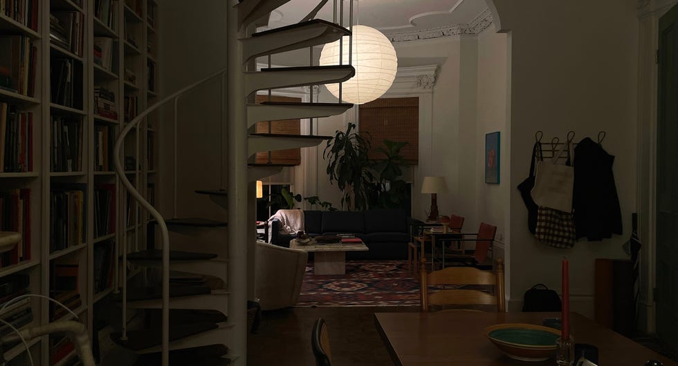 Interior of a dimly lit room with spiral staircase and various furniture.
