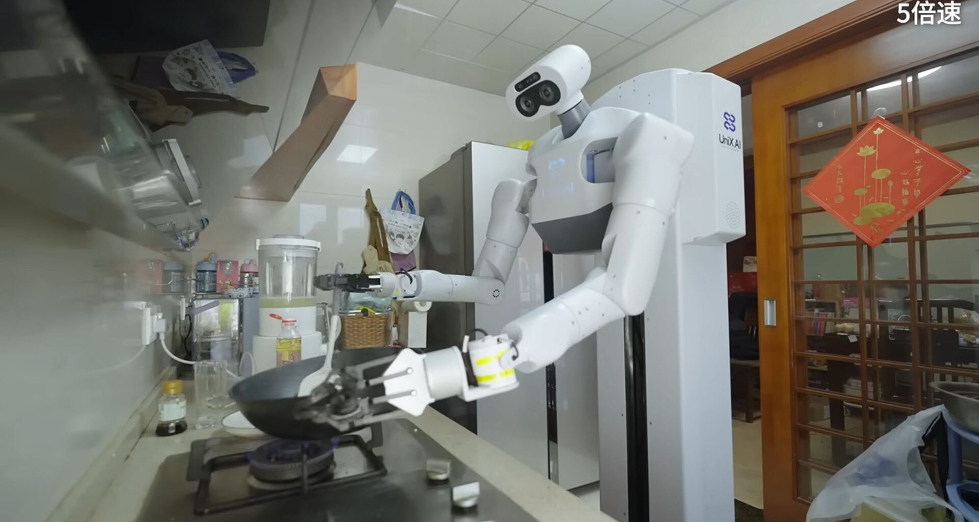 A white humanoid robot stands over a kitchen stove, holding utensils.