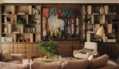 a layered living with a large wooden media wall and abstract artwork hiding the TV
