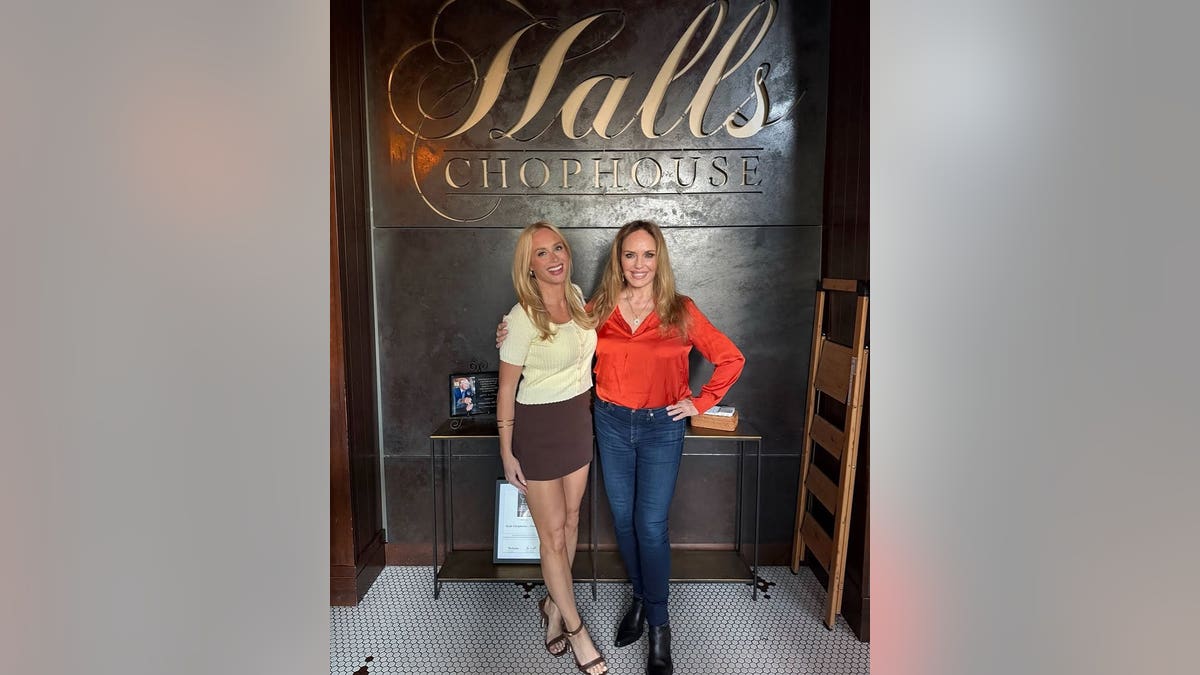 Catherine Bach smiling with a friend inside a Nashville steakhouse.