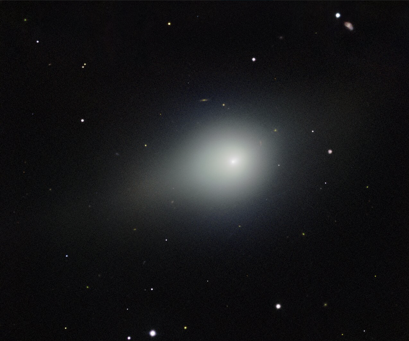 A large white fuzzy object, 3I/ATLAS, with a short tail in black space with small a few stars.