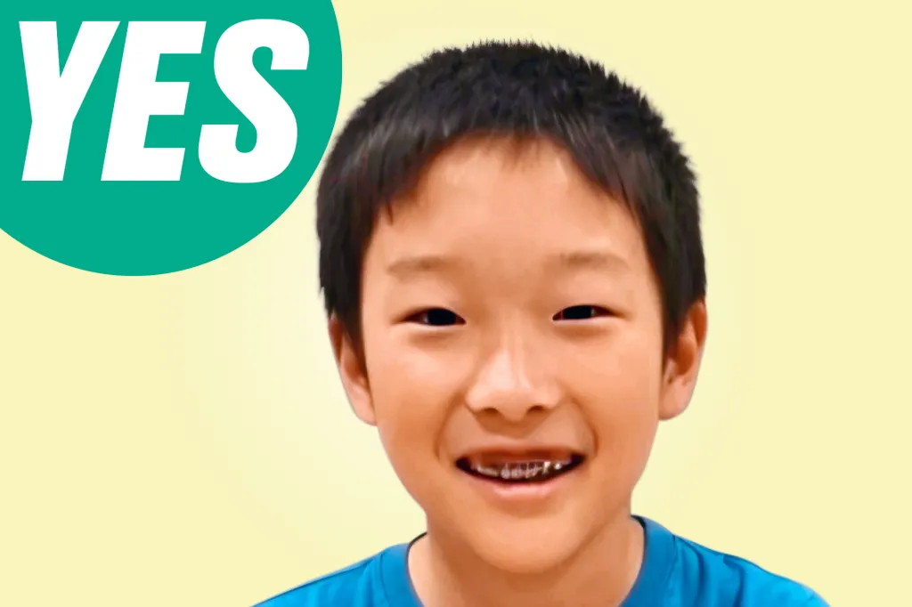 A smiling boy looks at the camera, with a green speech bubble that says “YES.”